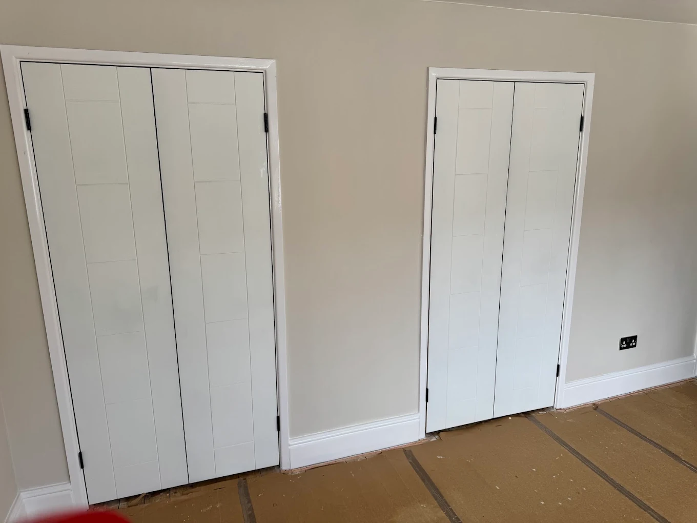 Period internal double doors painted in a dark finish, fitted to a hallway with original architrave