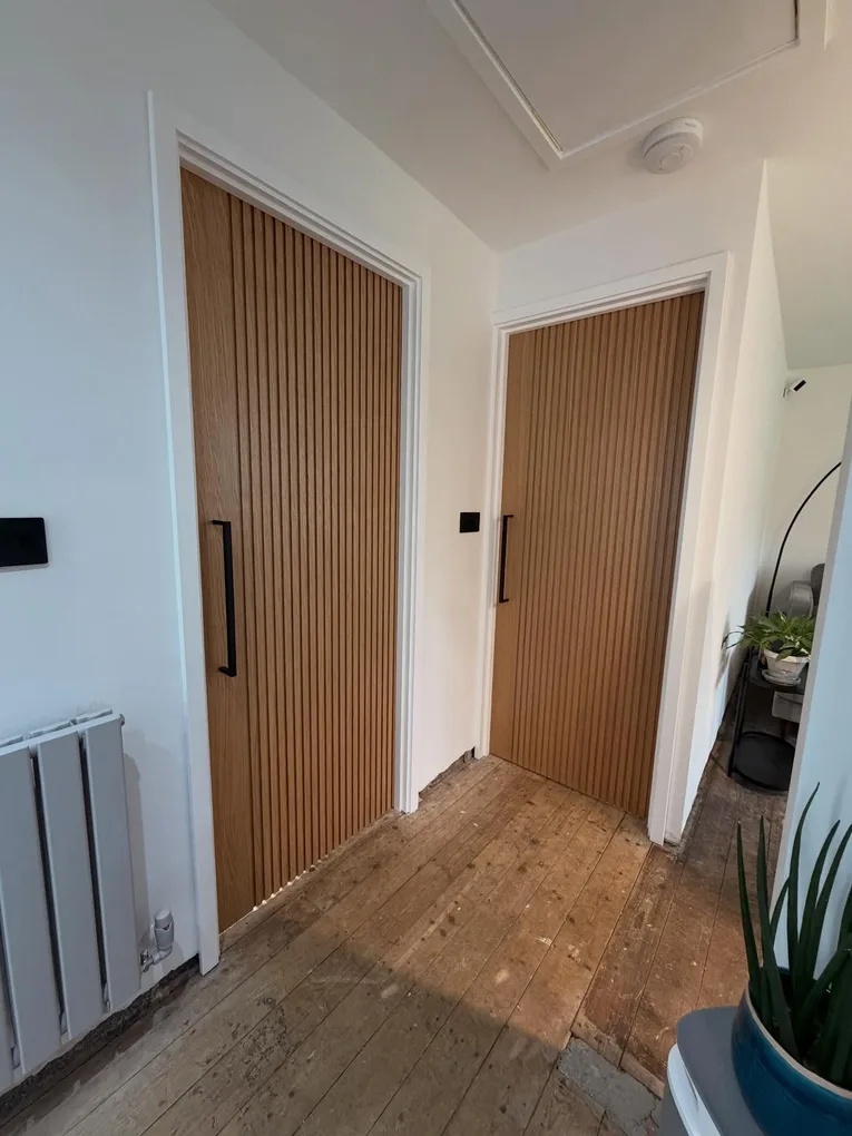 Contemporary pre-finished oak slat internal door with large black bar handle