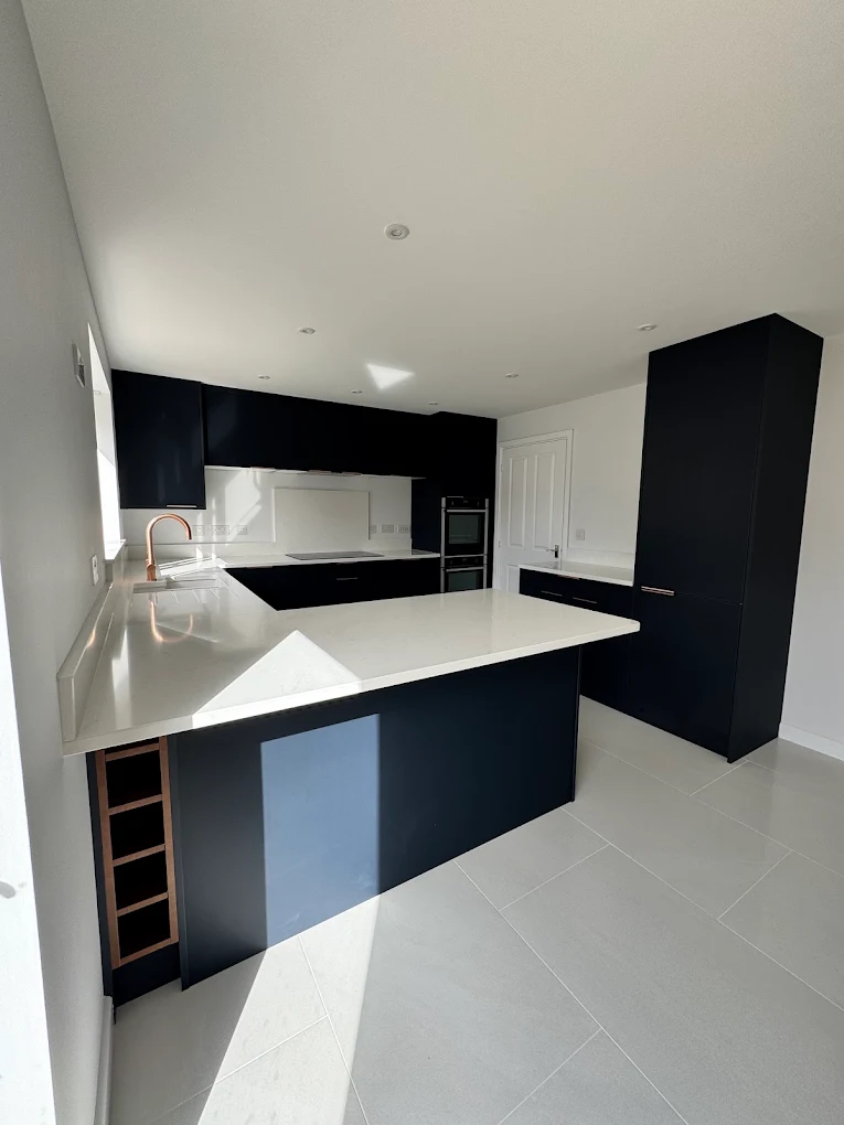 Light oak shaker kitchen with a peninsula breakfast bar and feature window